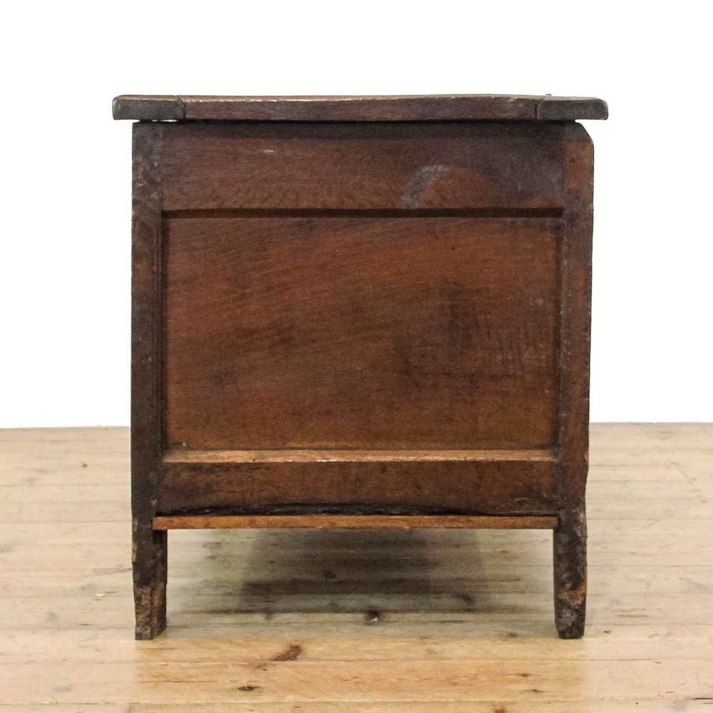A dark carved oak coffer featuring three front panels, geometric inlay along the frame, arcaded frieze carvings, and a central iron keyhole plate. View VI