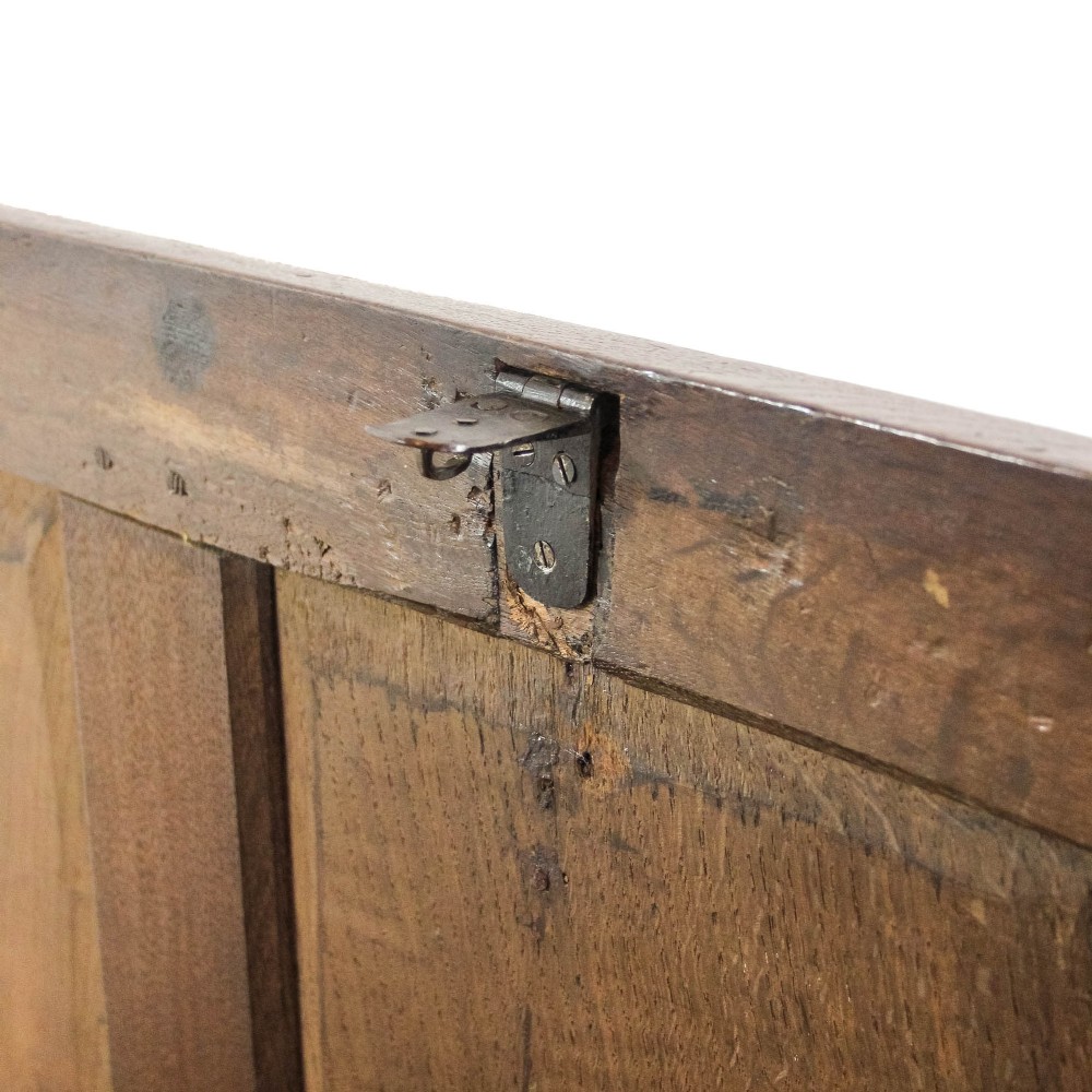 A dark carved oak coffer featuring three front panels, geometric inlay along the frame, arcaded frieze carvings, and a central iron keyhole plate. View X