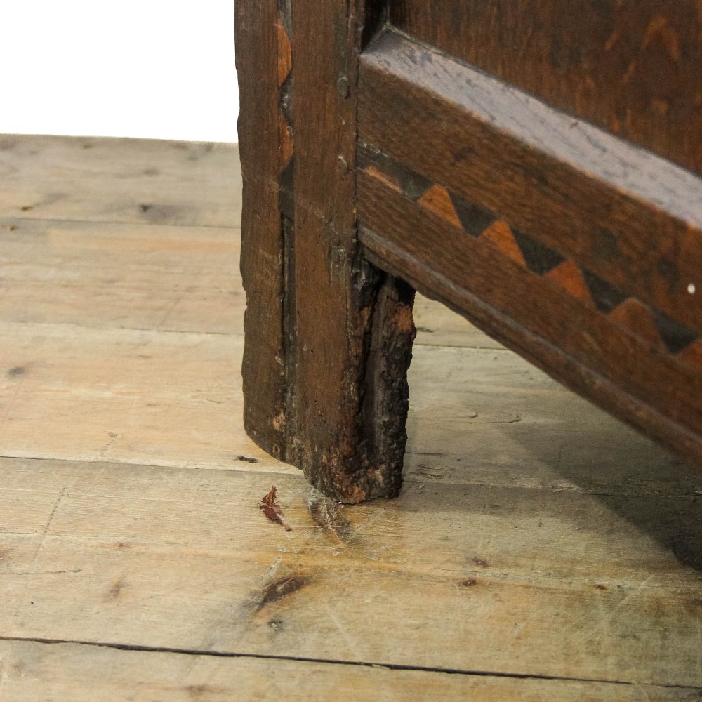 A dark carved oak coffer featuring three front panels, geometric inlay along the frame, arcaded frieze carvings, and a central iron keyhole plate. View XIII