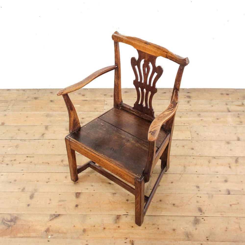 A George III period oak open armchair featuring a pierced vase-shaped back splat, swept arms, a solid wooden seat, and square legs joined by stretchers. View VI