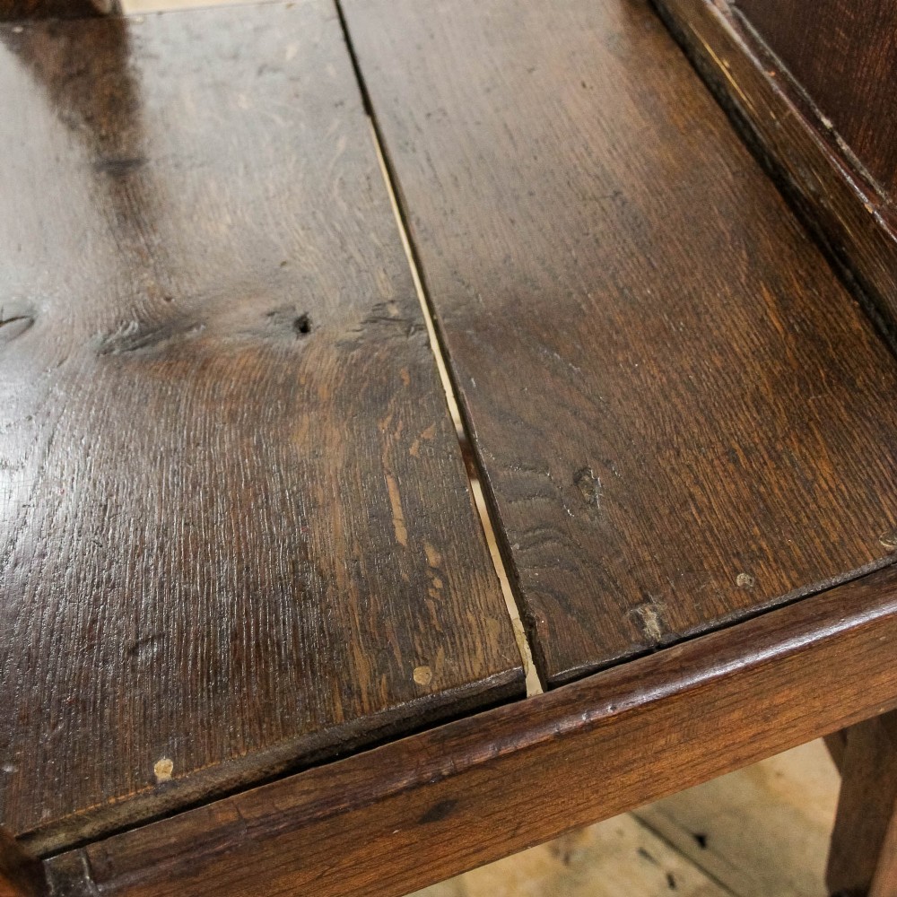 A George III period oak open armchair featuring a pierced vase-shaped back splat, swept arms, a solid wooden seat, and square legs joined by stretchers. View VII