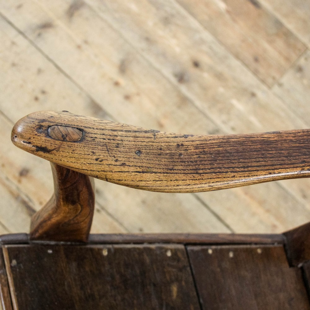 A George III period oak open armchair featuring a pierced vase-shaped back splat, swept arms, a solid wooden seat, and square legs joined by stretchers. View VIII