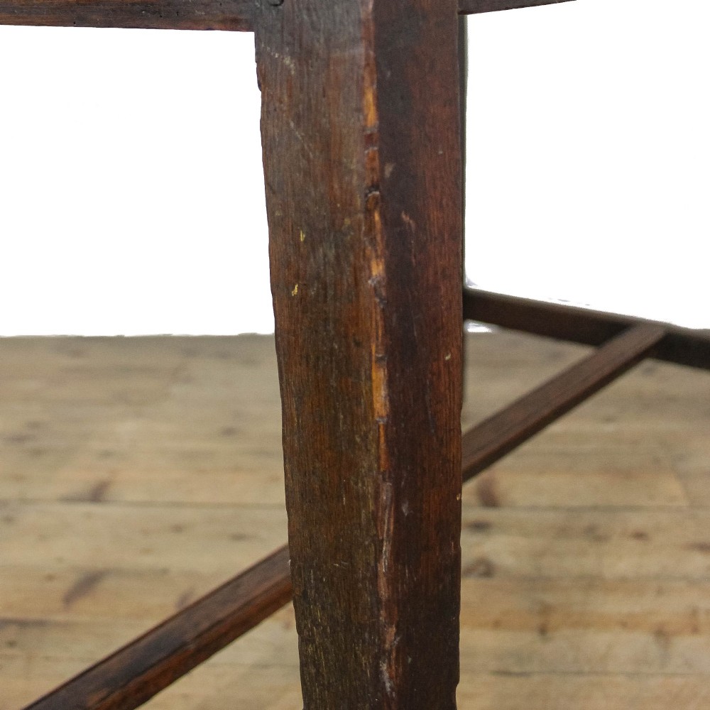 An antique dark oak kitchen table featuring a rectangular top, an end drawer with a brass knob, straight legs, and a low H-stretcher base. View III