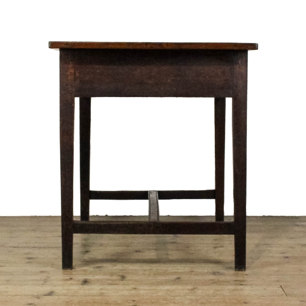 An antique dark oak kitchen table featuring a rectangular top, an end drawer with a brass knob, straight legs, and a low H-stretcher base. View X
