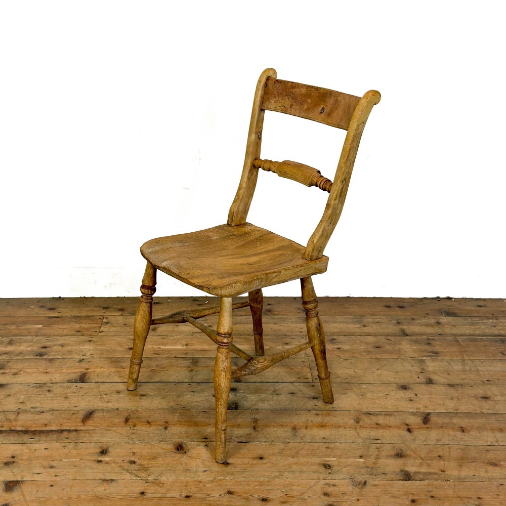 A set of six mismatched vintage wooden dining chairs with turned legs and varied slat and spindle backs arranged together. View VIII