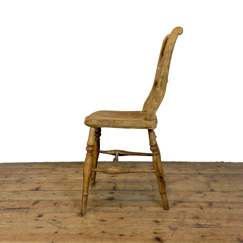 A set of six mismatched vintage wooden dining chairs with turned legs and varied slat and spindle backs arranged together. View IX