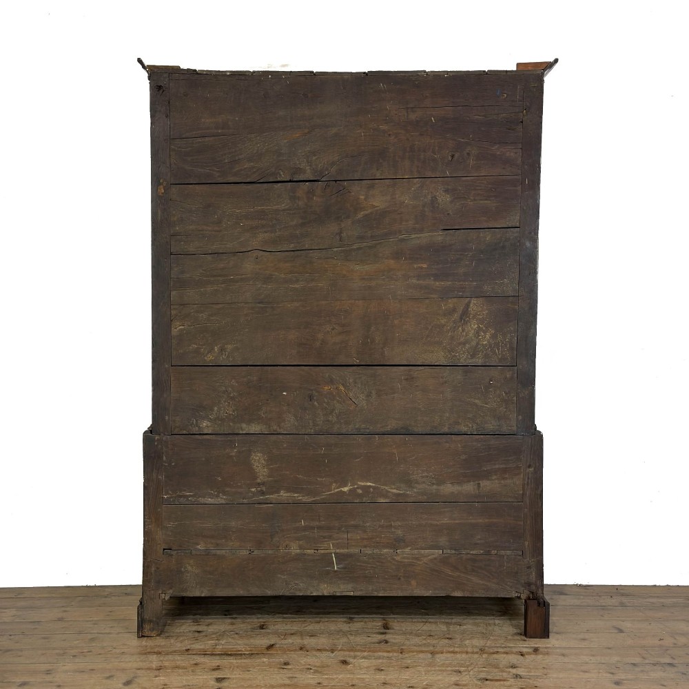 An eighteenth-century dark oak livery cupboard featuring double arched fielded panel doors over a lower drawer base with brass handles. View IX