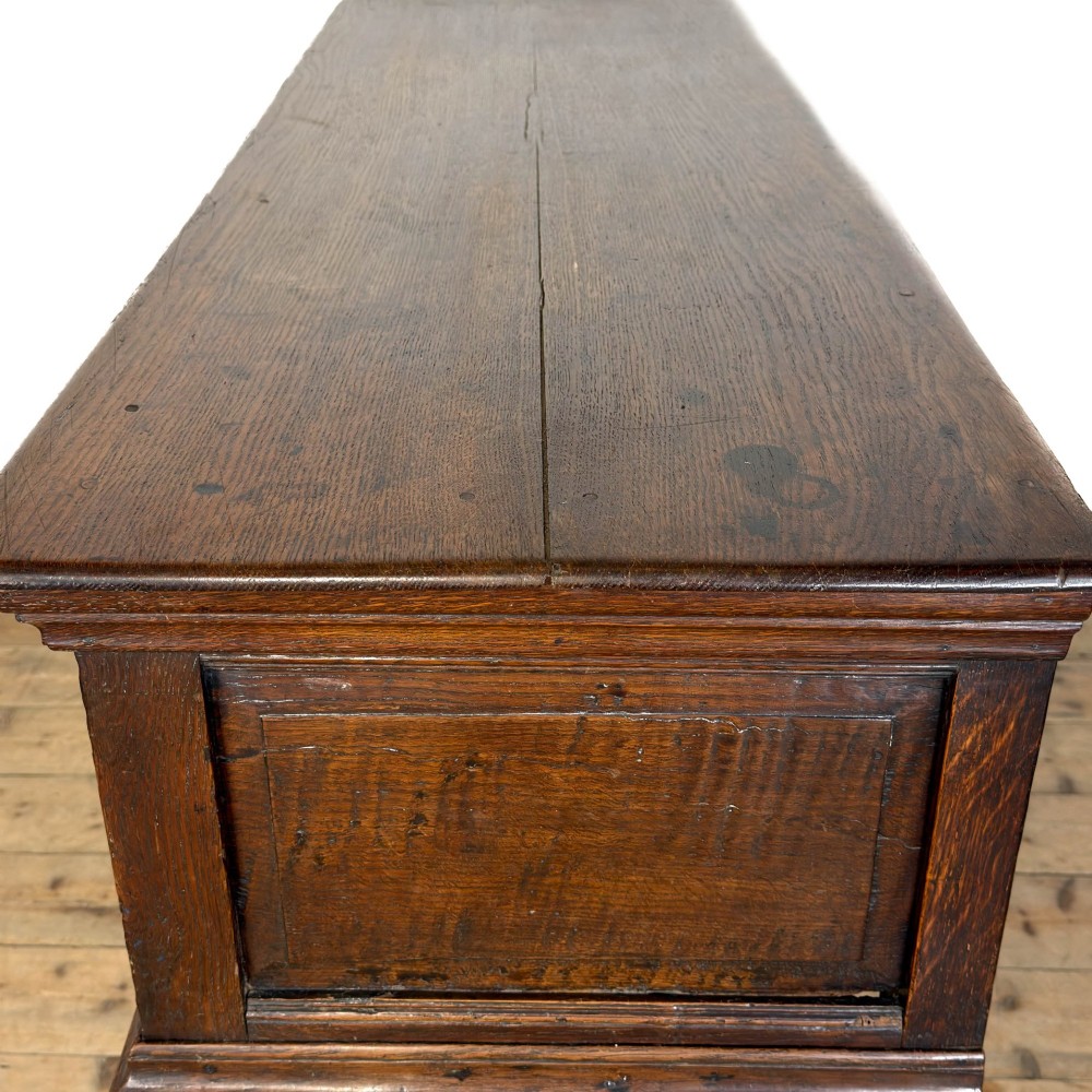 An antique dark oak dresser base featuring two drawers with geometric raised mouldings, brass handles, turned front legs, and a low stretcher. View VIII