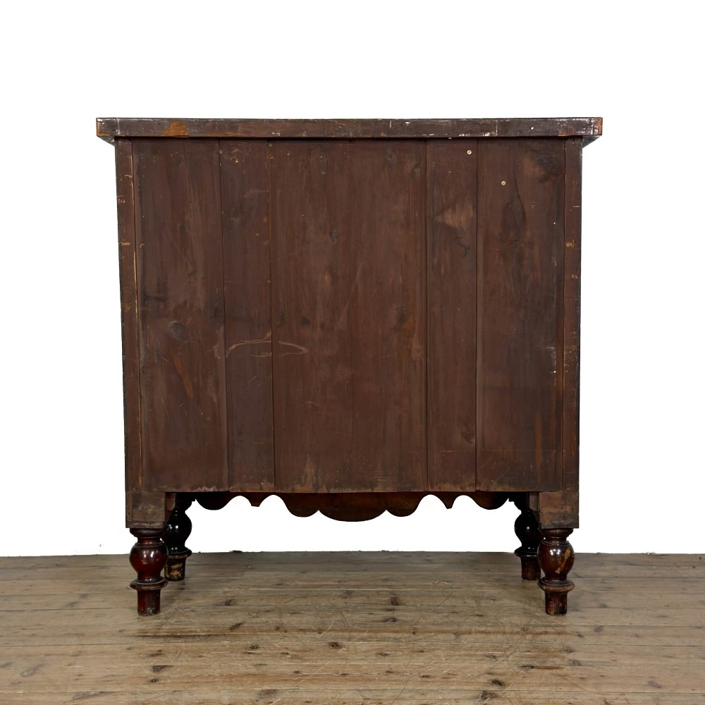 A Victorian mahogany chest of drawers featuring a bowfront profile, two short over three long graduating drawers, turned wooden knobs, and turned feet. View V