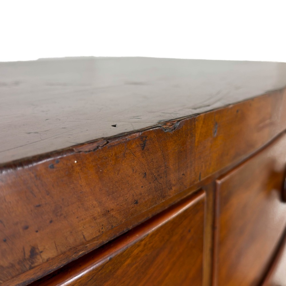 A Victorian mahogany chest of drawers featuring a bowfront profile, two short over three long graduating drawers, turned wooden knobs, and turned feet. View X