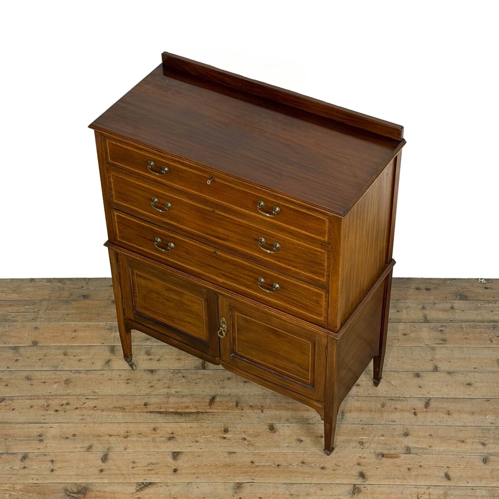 An antique Edwardian mahogany tallboy chest featuring three upper drawers above a double-door cupboard with satinwood string inlay and brass castors. View IV