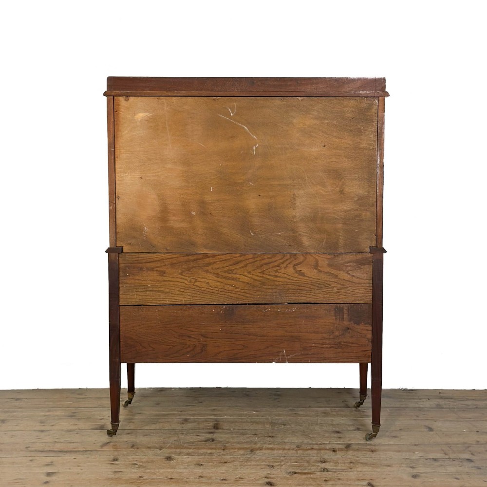 An antique Edwardian mahogany tallboy chest featuring three upper drawers above a double-door cupboard with satinwood string inlay and brass castors. View VII
