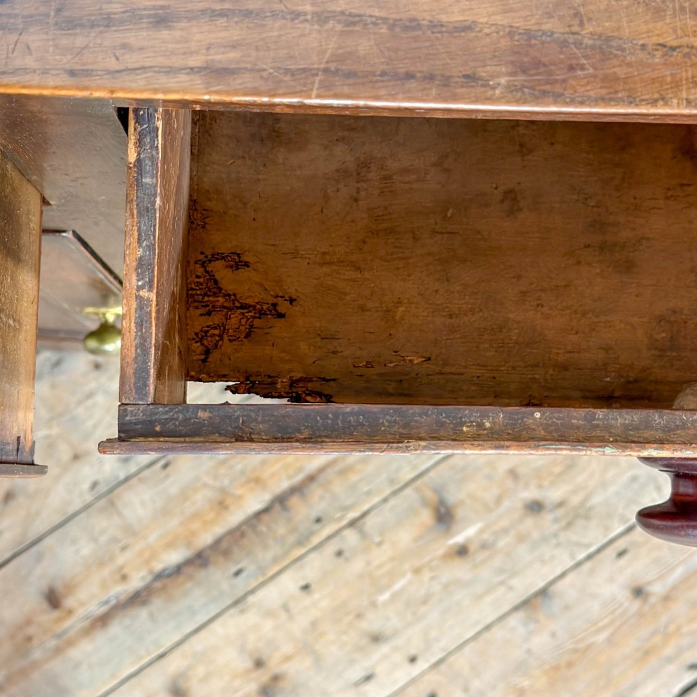 A dark oak antique dresser base featuring three top drawers with wooden knobs and brass keyholes above two panelled cupboards flanking a central open alcove. View VI