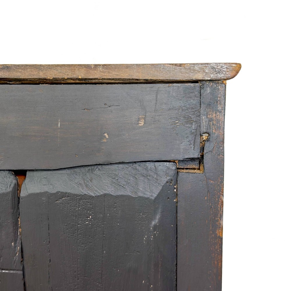 A dark oak antique dresser base featuring three top drawers with wooden knobs and brass keyholes above two panelled cupboards flanking a central open alcove. View X