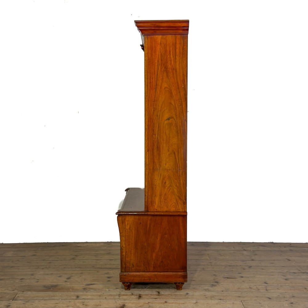 A tall antique open bookcase crafted from warm brown walnut featuring multiple open shelves, fluted side pilasters, and two lower drawers with brass drop handles. View VI