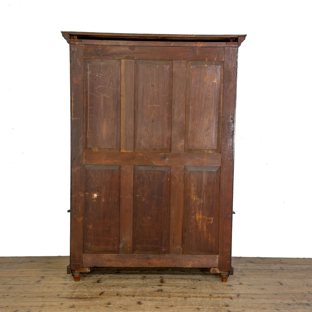A tall antique open bookcase crafted from warm brown walnut featuring multiple open shelves, fluted side pilasters, and two lower drawers with brass drop handles. View VII