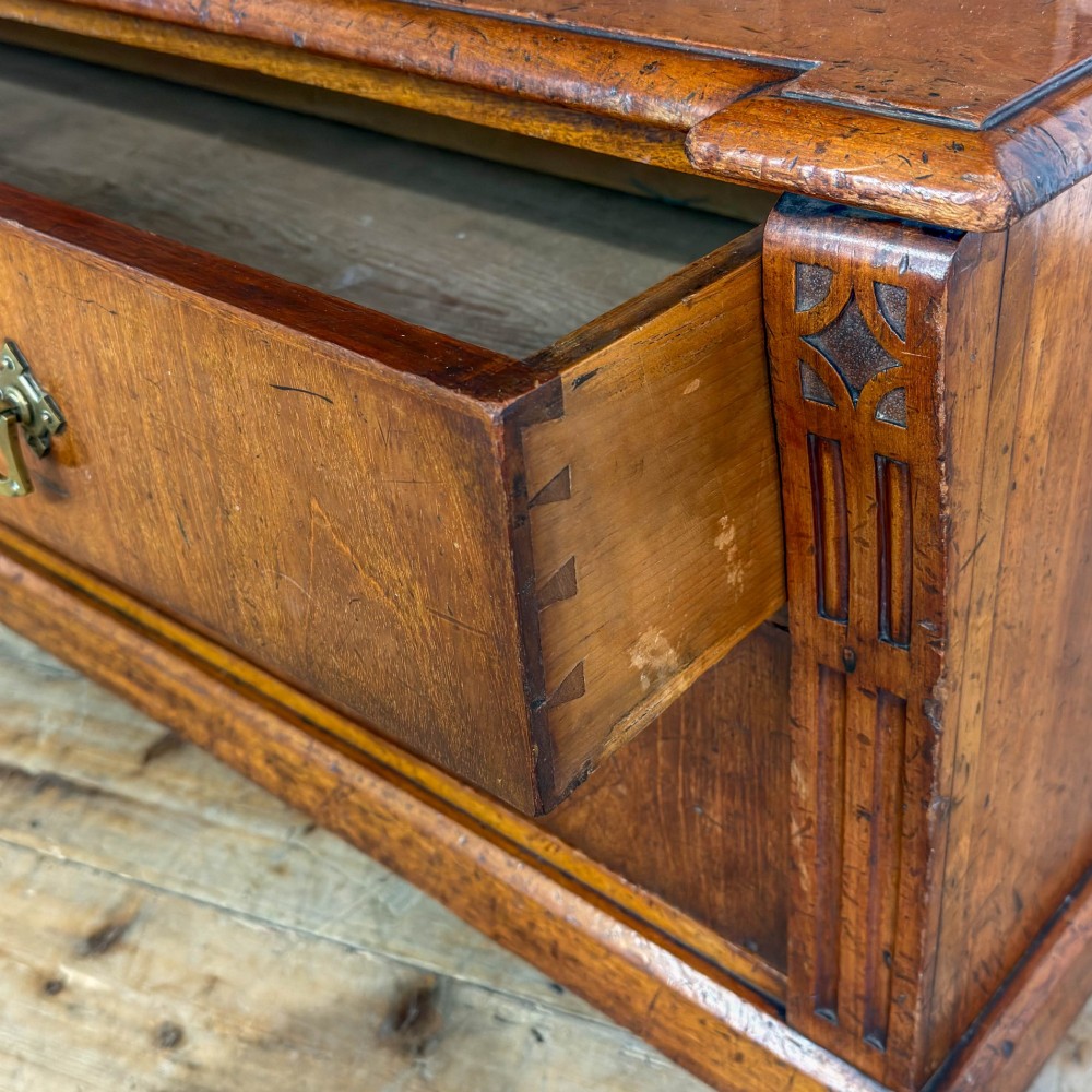 A tall antique open bookcase crafted from warm brown walnut featuring multiple open shelves, fluted side pilasters, and two lower drawers with brass drop handles. View IX