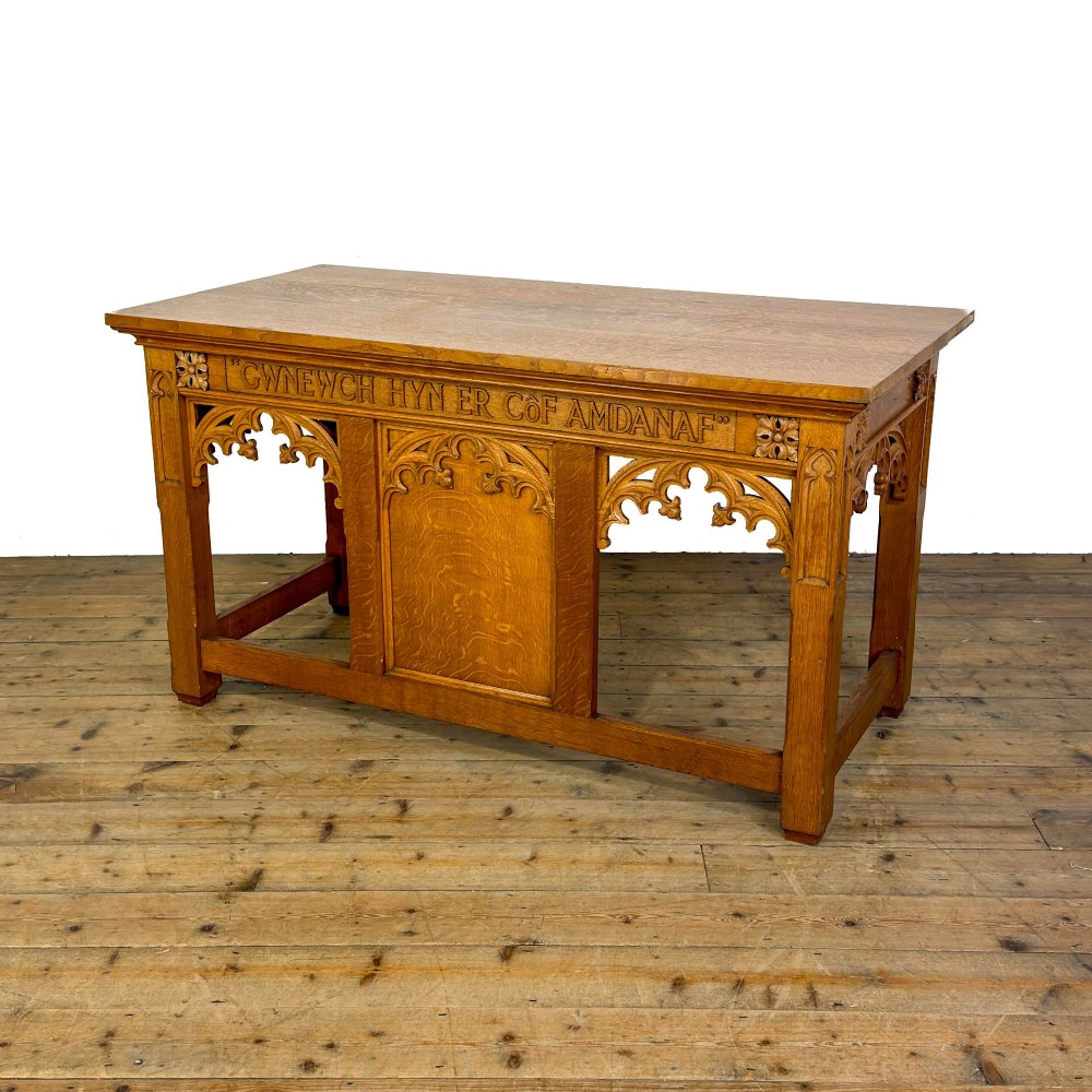 A carved oak Gothic Revival chapel altar table featuring trefoil tracery, an inscribed apron in Welsh script, and a solid rectangular top. View II