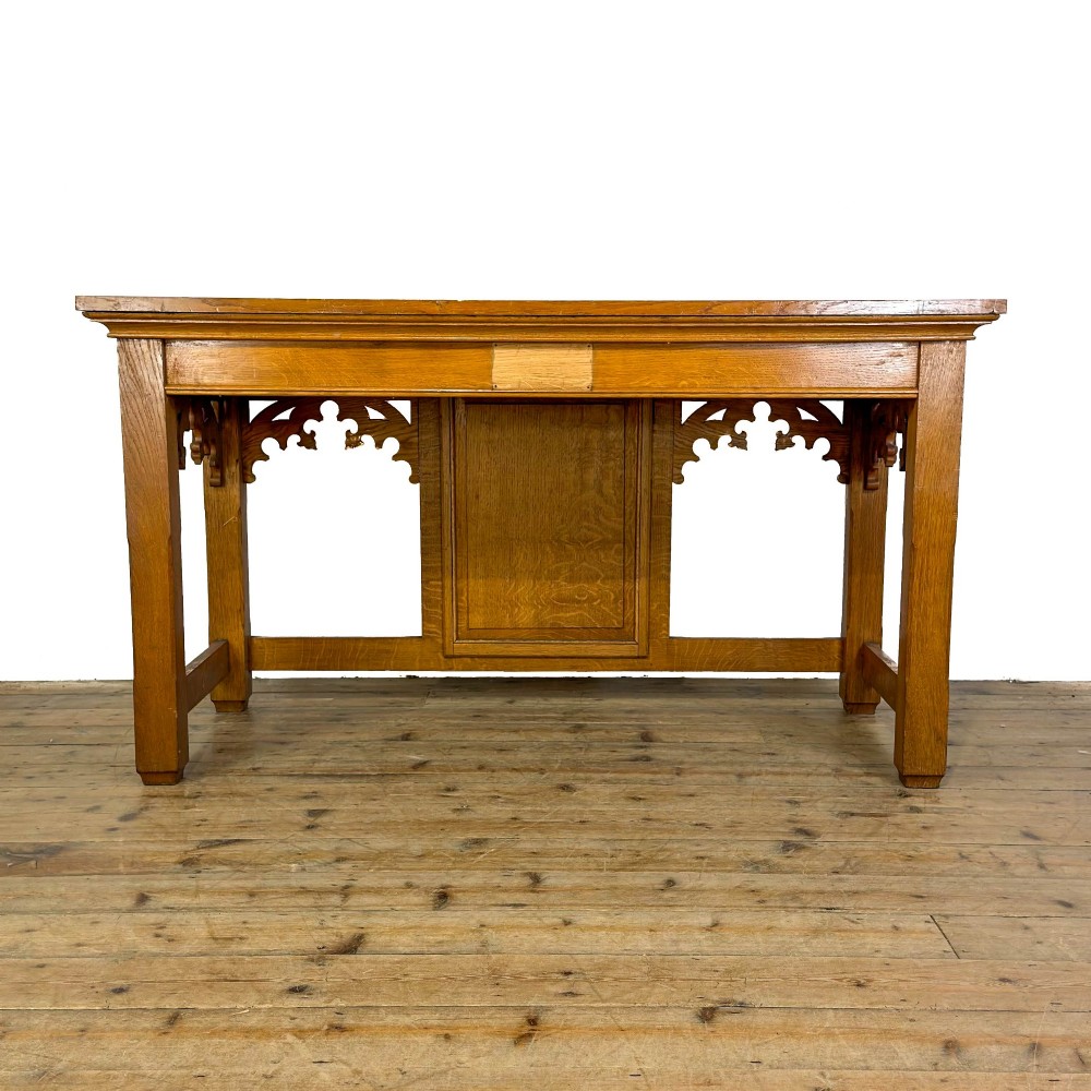 A carved oak Gothic Revival chapel altar table featuring trefoil tracery, an inscribed apron in Welsh script, and a solid rectangular top. View V