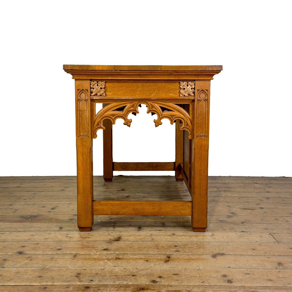 A carved oak Gothic Revival chapel altar table featuring trefoil tracery, an inscribed apron in Welsh script, and a solid rectangular top. View VI
