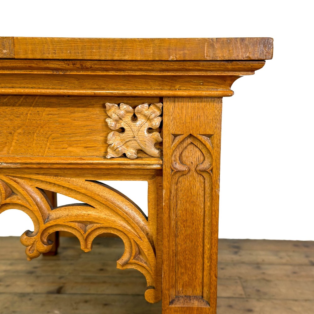 A carved oak Gothic Revival chapel altar table featuring trefoil tracery, an inscribed apron in Welsh script, and a solid rectangular top. View VII