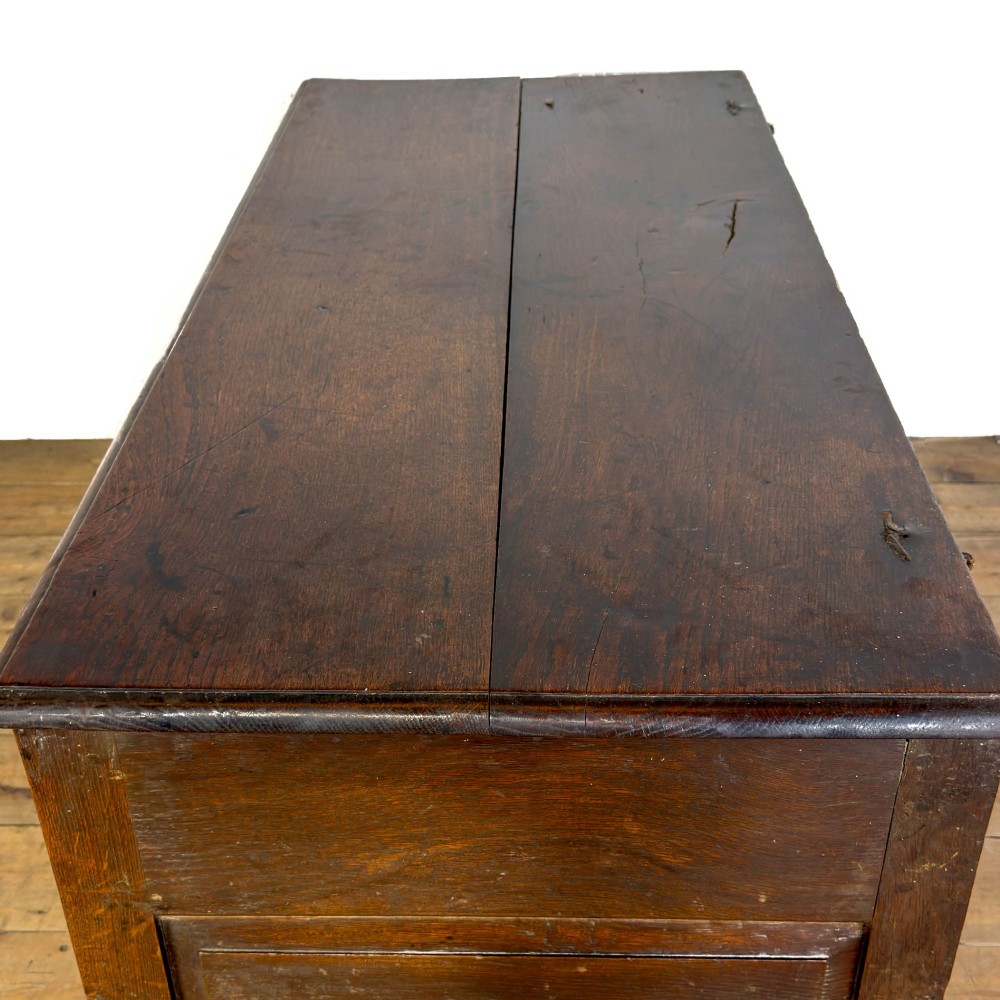 A 19th-century warm brown oak coffer featuring three fielded front panels, a brass keyhole escutcheon, and a flat hinged top lid. View VII