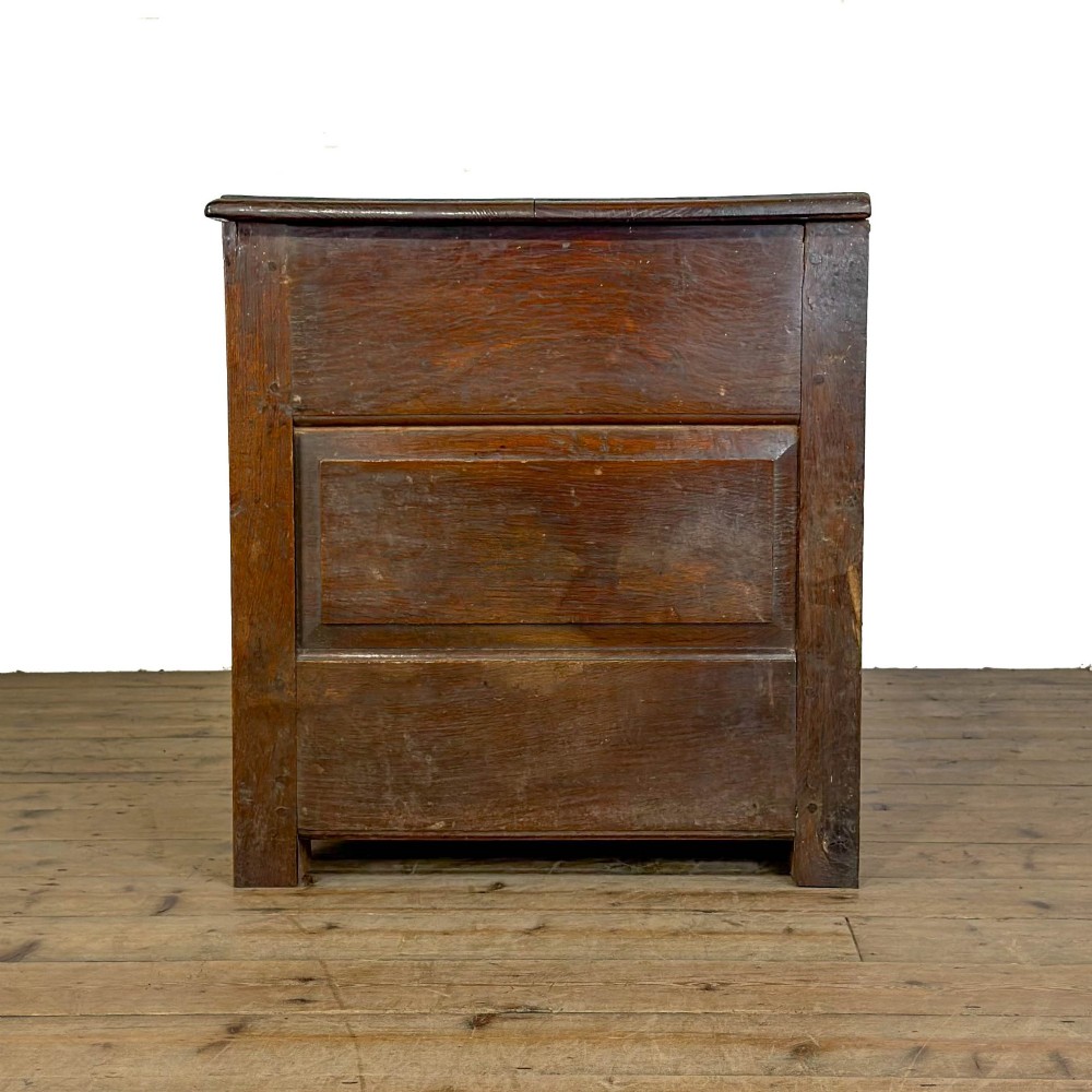 A 19th-century warm brown oak coffer featuring three fielded front panels, a brass keyhole escutcheon, and a flat hinged top lid. View VIII
