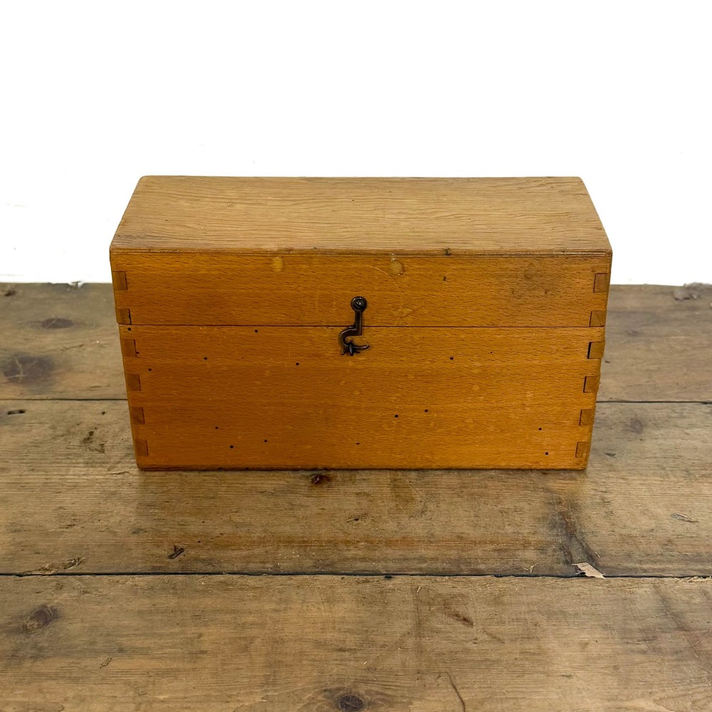 An antique dark oak church hymn board featuring a trefoil cutout at the carved top, painted text reading HYMNS, multiple horizontal slots, and an accompanying wooden box. View VI