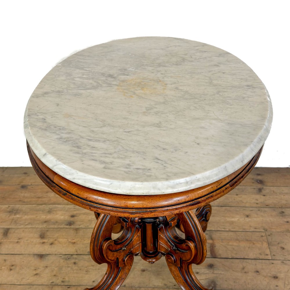 A circular Victorian side table featuring a white marble top supported by a carved mahogany pedestal base with scrolled legs. View VI