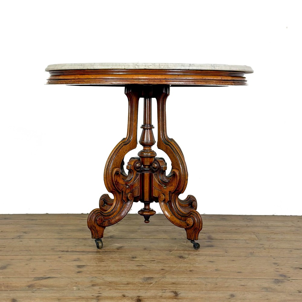 A circular Victorian side table featuring a white marble top supported by a carved mahogany pedestal base with scrolled legs. View VII