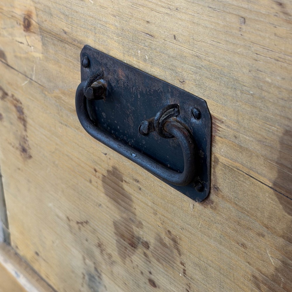 A rectangular stripped pine trunk displaying visible dovetail joints, a brass keyhole escutcheon, and a simple plinth base. View II