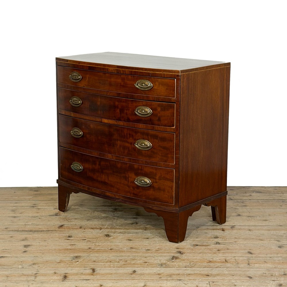 An antique Georgian mahogany bow-front chest of drawers with four graduated drawers and brass oval drop handles. View II