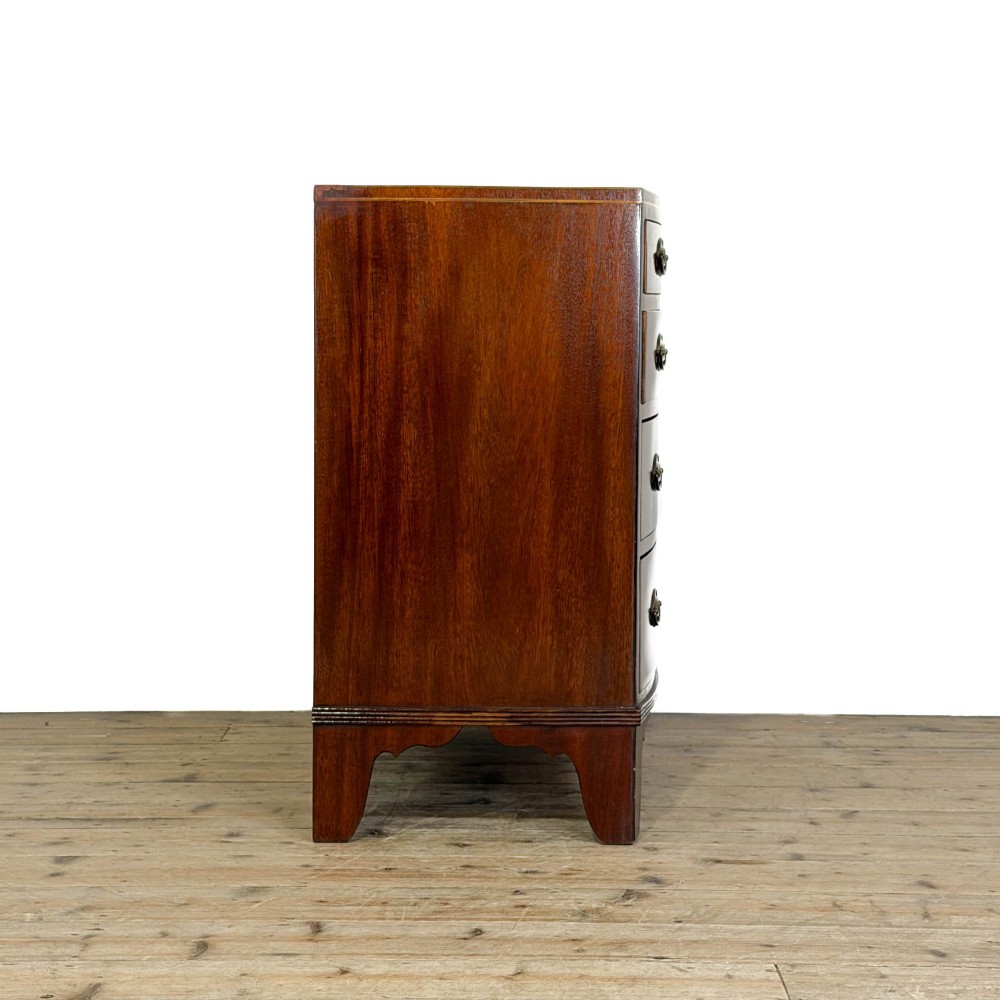 An antique Georgian mahogany bow-front chest of drawers with four graduated drawers and brass oval drop handles. View VI