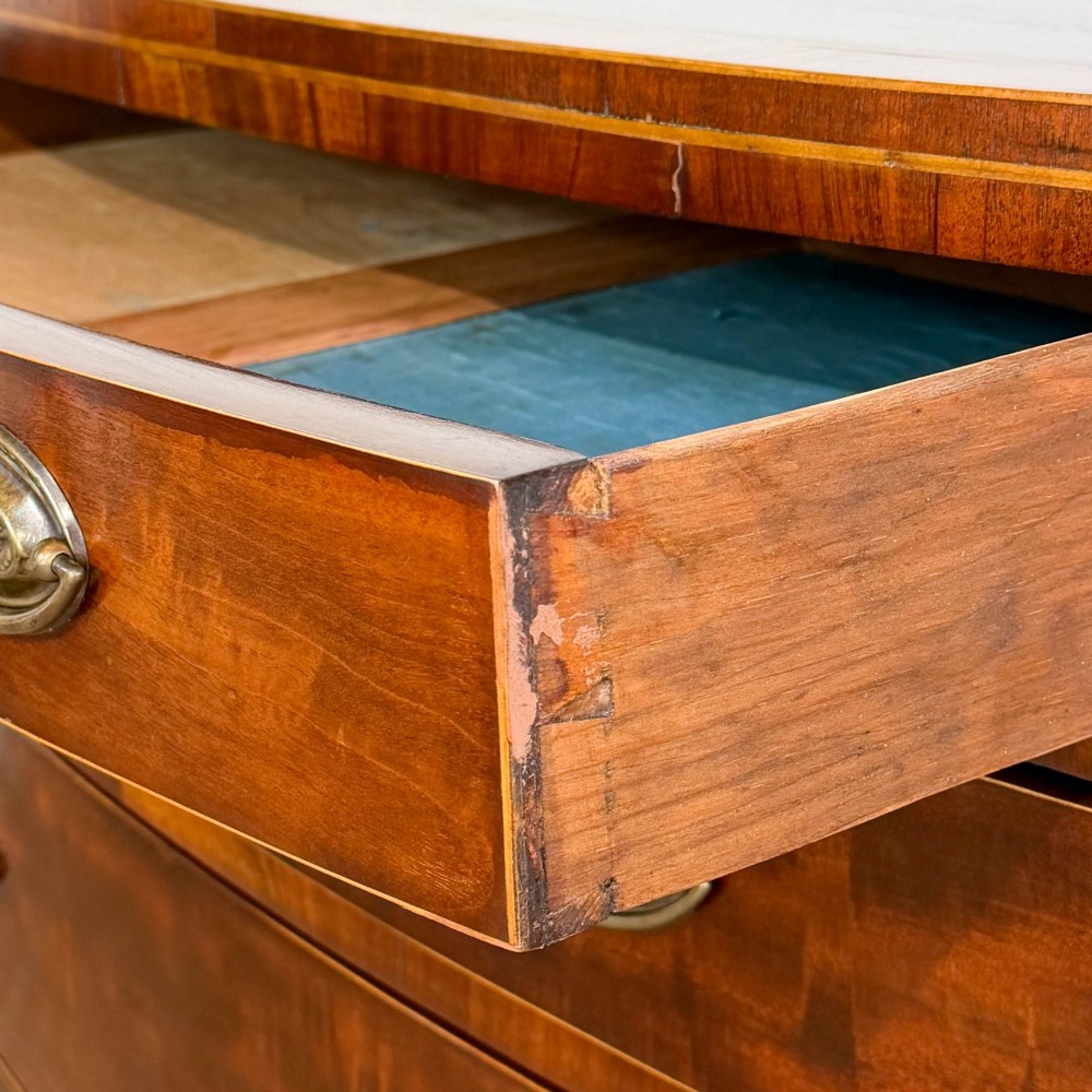 An antique Georgian mahogany bow-front chest of drawers with four graduated drawers and brass oval drop handles. View VII