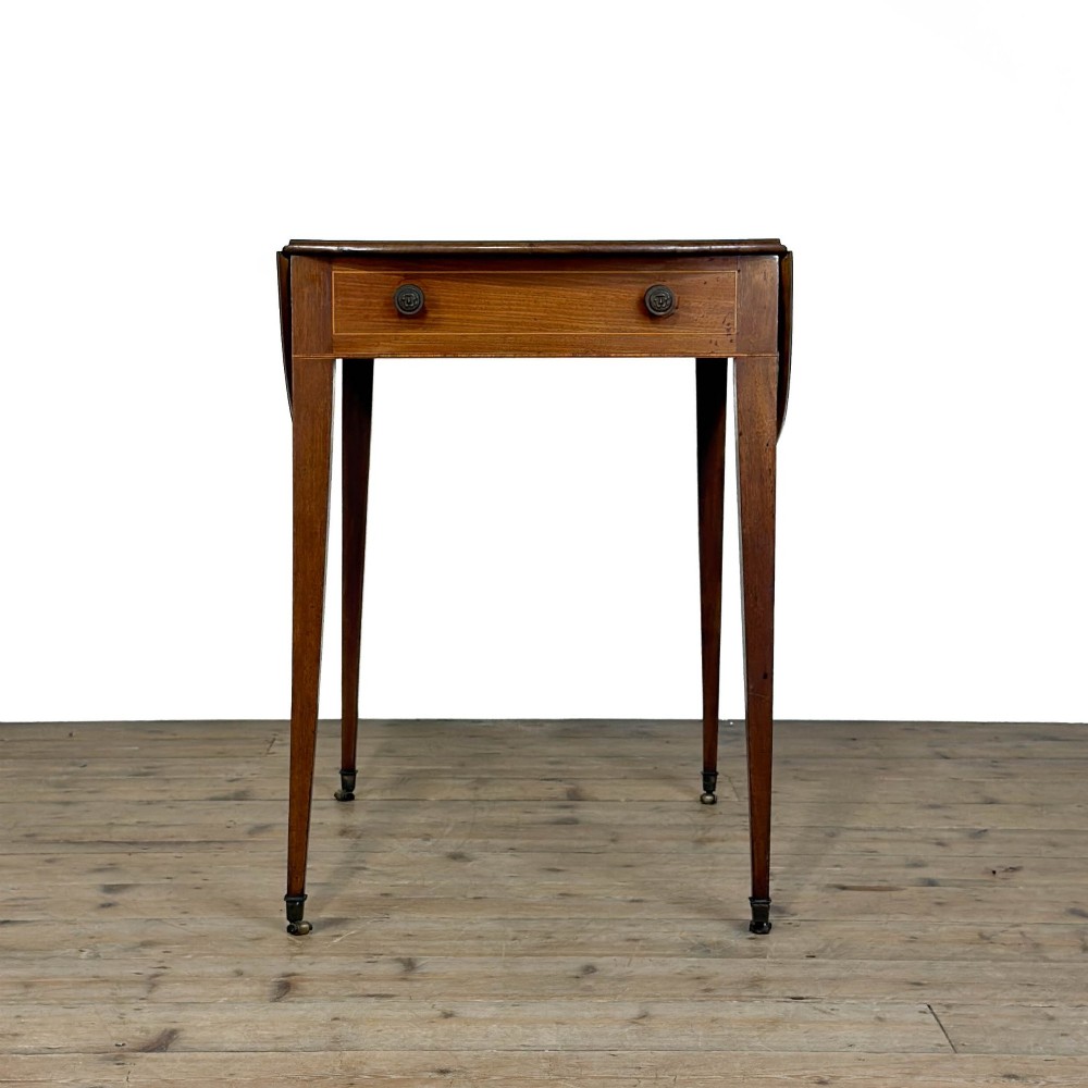 A 19th-century mahogany Pembroke table featuring two curved drop leaves, a single drawer with round brass knobs, and four square tapered legs on castors. View IV