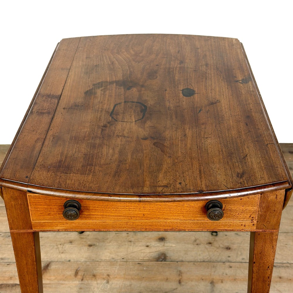 A 19th-century mahogany Pembroke table featuring two curved drop leaves, a single drawer with round brass knobs, and four square tapered legs on castors. View VI