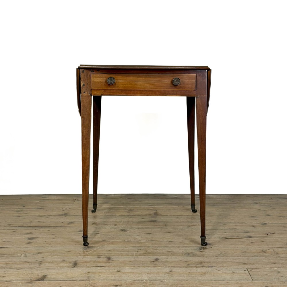A 19th-century mahogany Pembroke table featuring two curved drop leaves, a single drawer with round brass knobs, and four square tapered legs on castors. View X