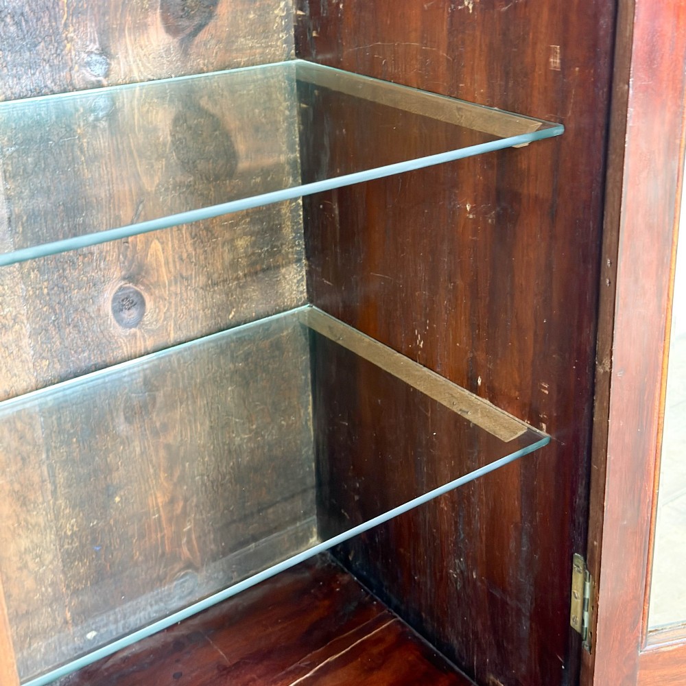 An antique dark wood Art Nouveau display cabinet featuring floral marquetry inlays, a single glazed glass door, and a shaped cresting gallery. View VI
