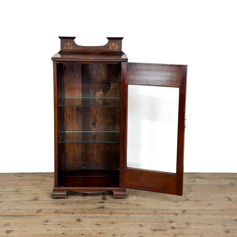 An antique dark wood Art Nouveau display cabinet featuring floral marquetry inlays, a single glazed glass door, and a shaped cresting gallery. View XI