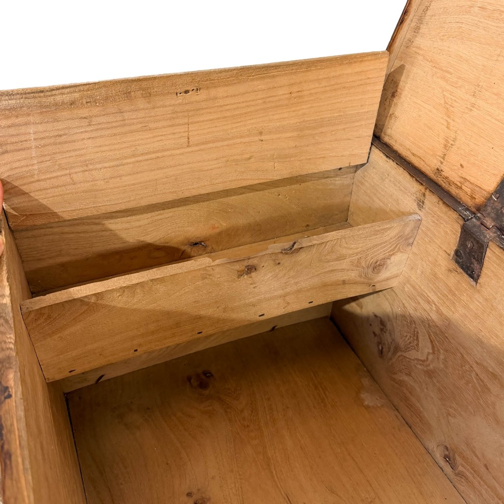 A rectangular George III dark elm blanket chest with a hinged lid, brass escutcheon, and bracket feet. View IV