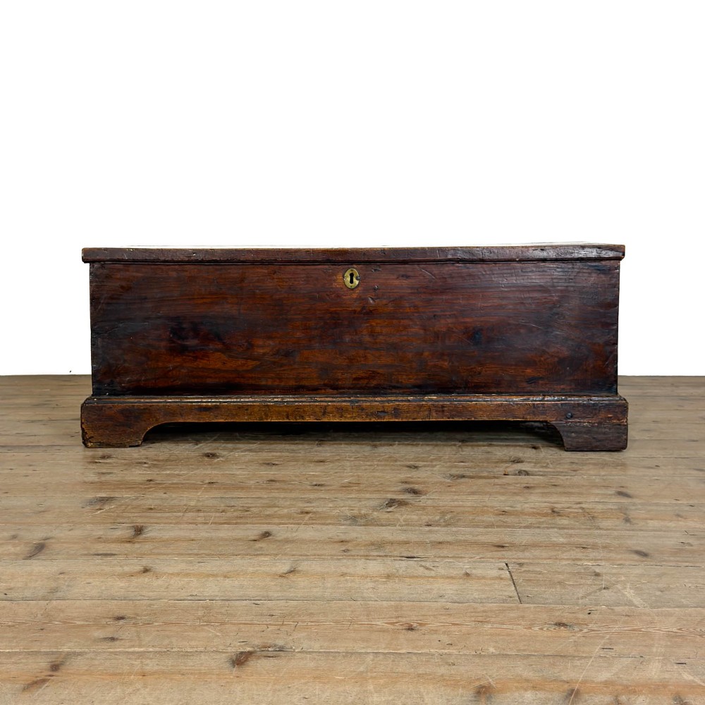 A rectangular George III dark elm blanket chest with a hinged lid, brass escutcheon, and bracket feet. View XI