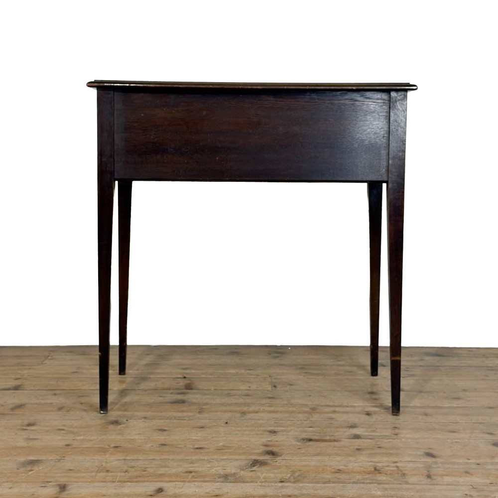 A dark oak lowboy table with two stacked drawers featuring brass drop handles and tapered square legs. View VIII