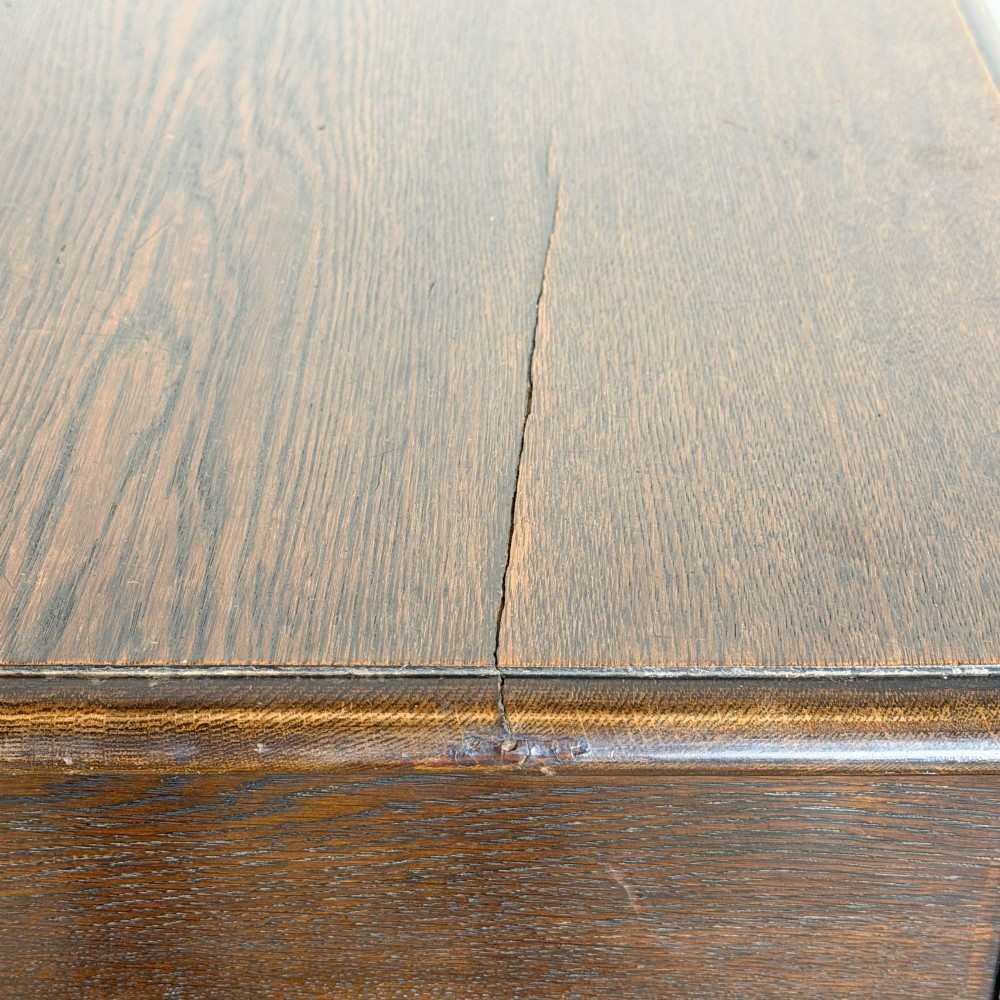 A dark oak lowboy table with two stacked drawers featuring brass drop handles and tapered square legs. View IX
