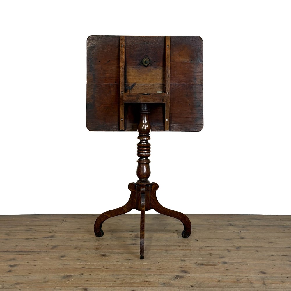 A 19th-century oak tilt-top table featuring a rectangular surface set upon a turned central column with three cabriole tripod legs. View V