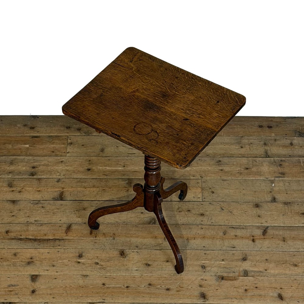 A 19th-century oak tilt-top table featuring a rectangular surface set upon a turned central column with three cabriole tripod legs. View IX