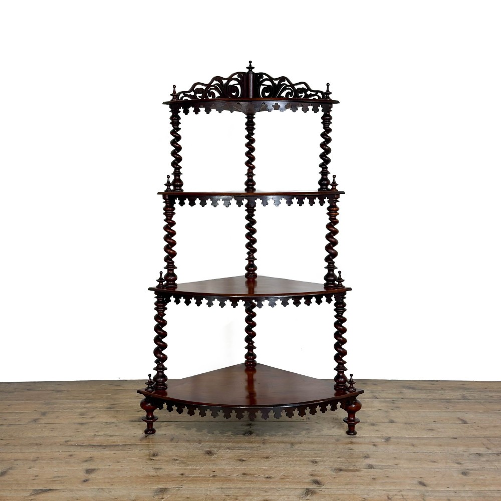 A four-tier Victorian mahogany corner whatnot featuring open shelving supported by barley twist columns and topped with a pierced fretwork pediment.