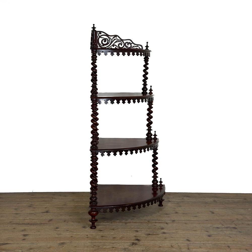 A four-tier Victorian mahogany corner whatnot featuring open shelving supported by barley twist columns and topped with a pierced fretwork pediment. View V