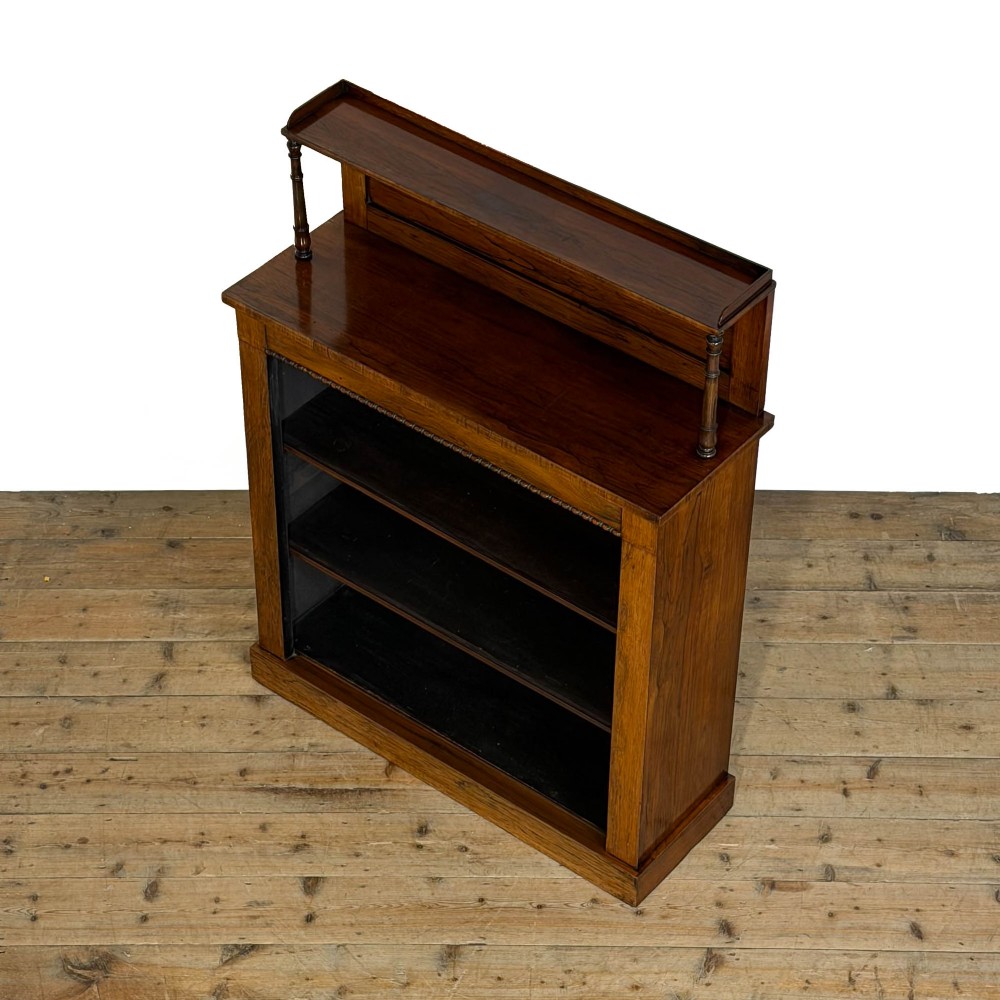 An antique rosewood open bookcase featuring a raised back gallery flanked by turned columns, with three open shelves and a beaded trim. View IV