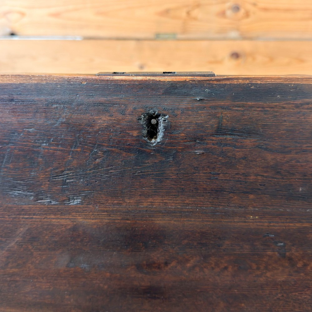 An antique stained pine blanket box featuring a flat hinged lid, dark wood finish, moulded plinth base, and central keyhole escutcheon. View II