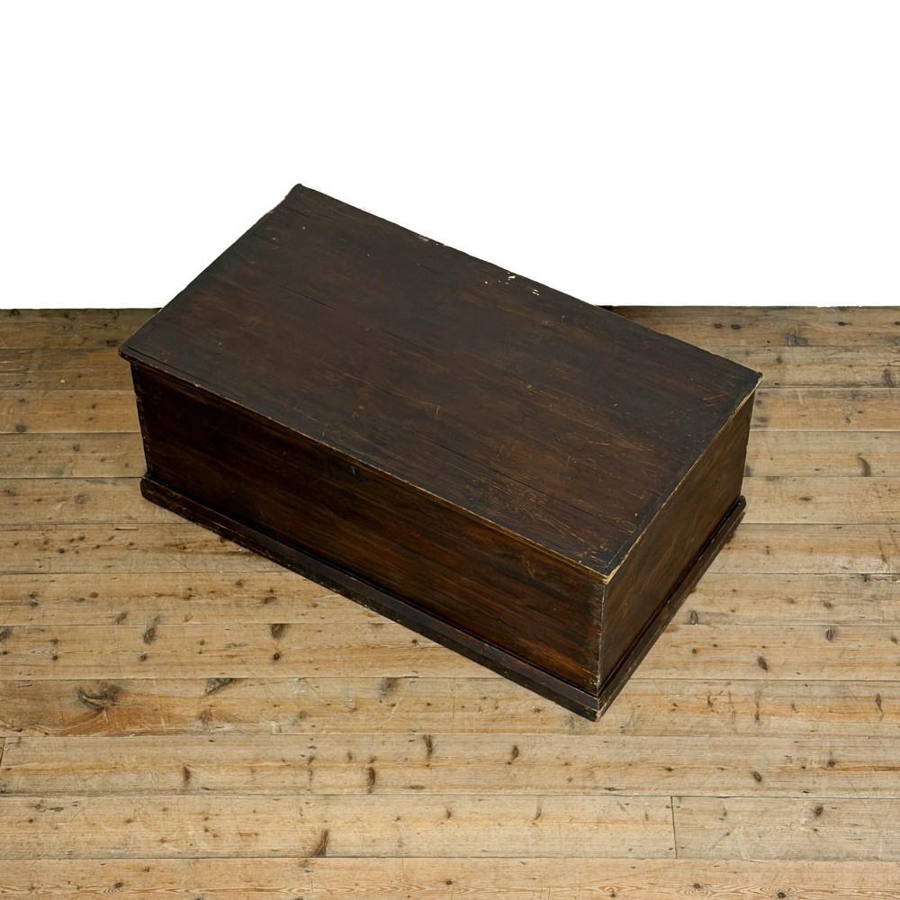 An antique stained pine blanket box featuring a flat hinged lid, dark wood finish, moulded plinth base, and central keyhole escutcheon. View IV